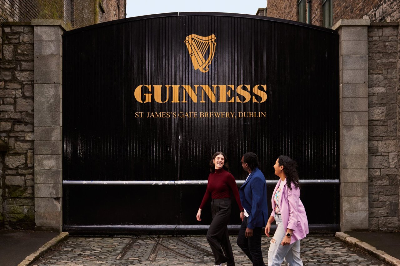 three people walking in front of the guinness storehouse tour